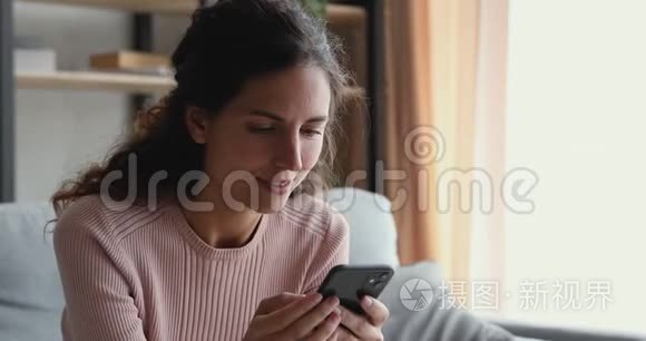 微笑的千禧一代女人在看智能手机的视频故事