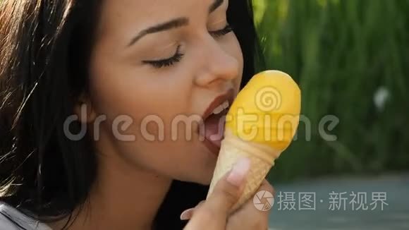 年轻美女微笑着吃着黄色高清电视里的冰淇淋