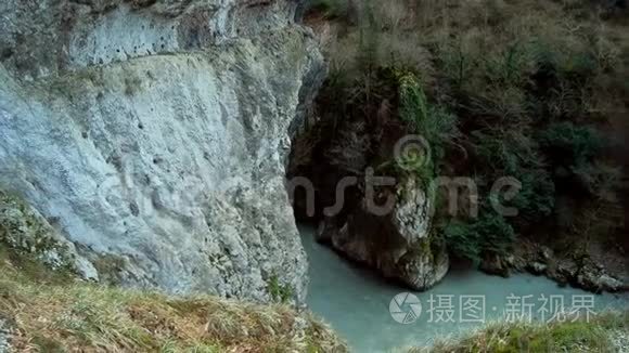 一位年轻的女摄影师背着背包沿着一条美丽的山路旅行