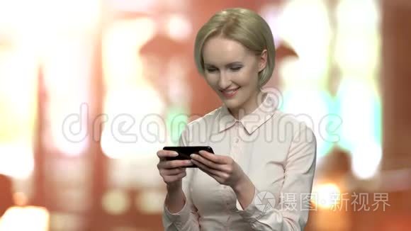 女人在她的触摸电话上玩游戏。