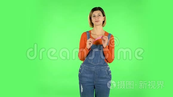 女孩用粉红色指甲锉做指甲。 绿色屏幕