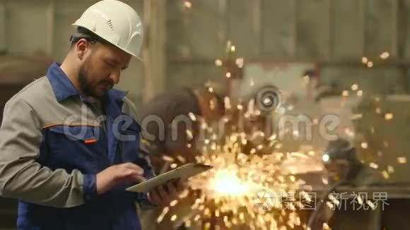 在重工业工厂使用平板电脑的工程师。 打磨火花背景