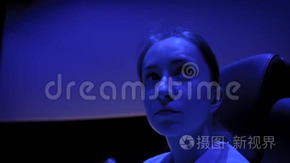 女人的脸看着电影院周围的蓝光照明