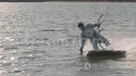 穿着医用个人防护装备的男子在海洋风筝冲浪，极限夏季运动慢动作。 病毒