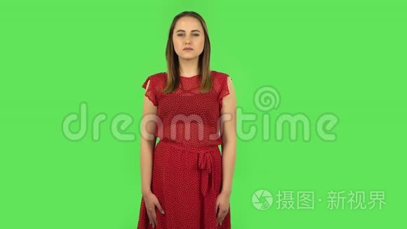 穿着红色衣服的温柔女孩用震惊的表情说哇。 绿色屏幕