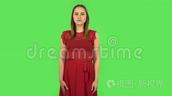 穿着红色衣服的温柔女孩用震惊的表情说哇。 绿色屏幕