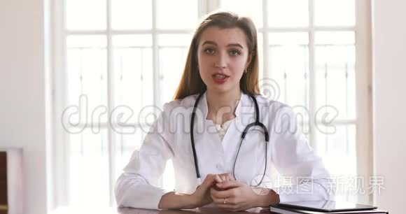 年轻的女医生穿着白色制服看着镜头