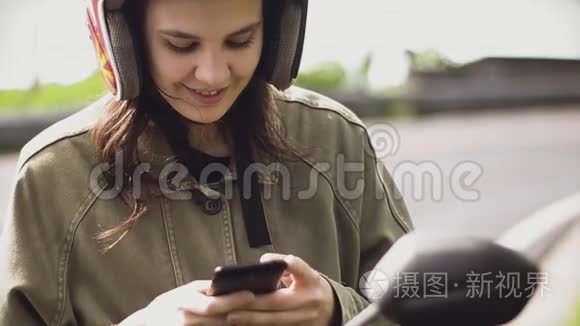 女孩旅行者在电话里发短信，在日出时停在路边的自行车上