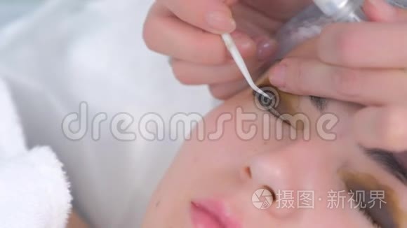 美容师用针头将睫毛弯曲成卷发器，抬起睫毛。