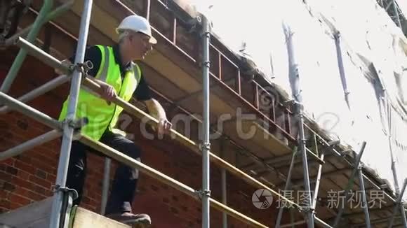 建筑工地站在脚手架上的男建筑工头、工人、测量员或建筑师