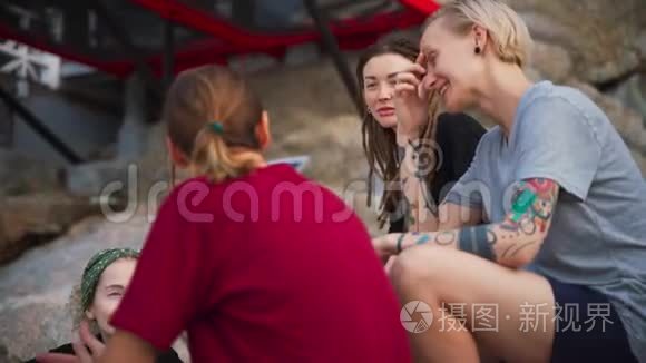 四个年轻女人组成的小组，最好的朋友坐在户外聊天。