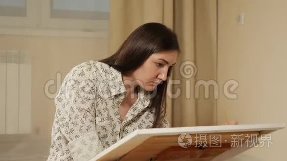 美丽的年轻女子画了一幅画视频