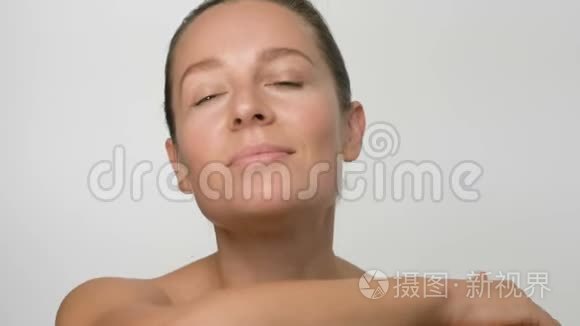 特写美女肖像的年轻女子光滑健康的皮肤，她看相机的白色背景和