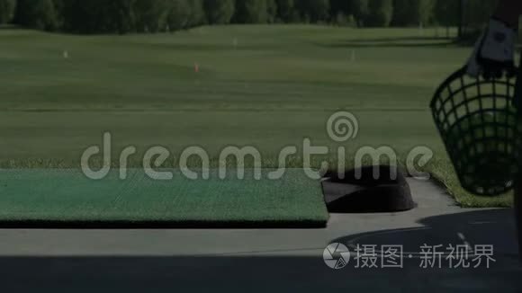 年轻的高尔夫球手在练习场练习高尔夫挥杆，从侧面观看