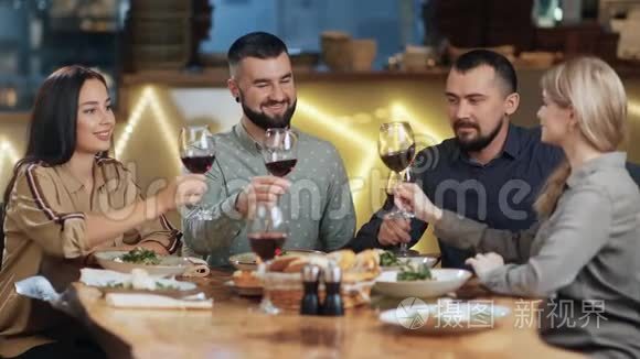 一群快乐的朋友在豪华餐厅喝着酒，碰杯。 4K红色相机拍摄