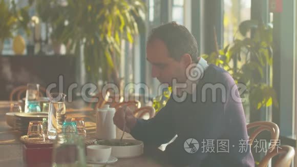 男人坐在咖啡馆的桌子旁吃沙拉视频