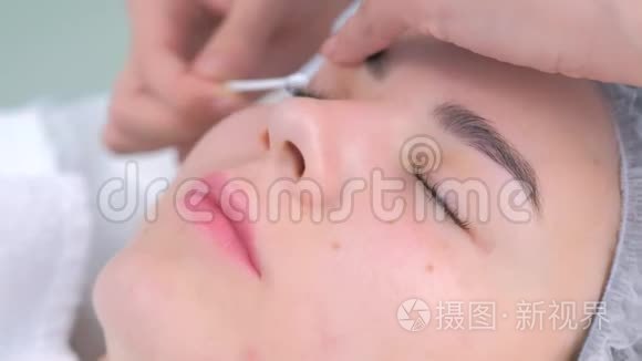 美容师擦拭眼睛棉棒后睫毛分层提升程序。