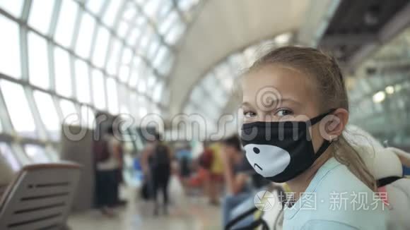 儿童白种人在机场，头上戴着防护医疗面罩，以飞机为背景。 冠状病毒
