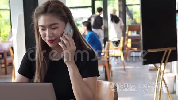 美丽迷人的亚洲商务女性，在咖啡厅使用智能手机或手机，微笑和快乐