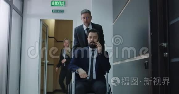 轮椅经理在办公室走廊打电话视频