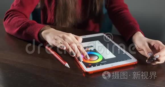 关闭女设计师坐在办公桌前工作。 当代年轻女性用数字平板电脑画笔