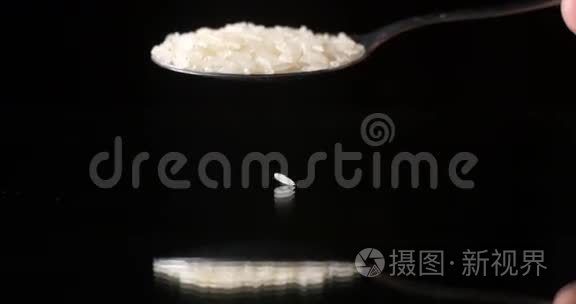 黑色背景反射桌面上落下的生米粒