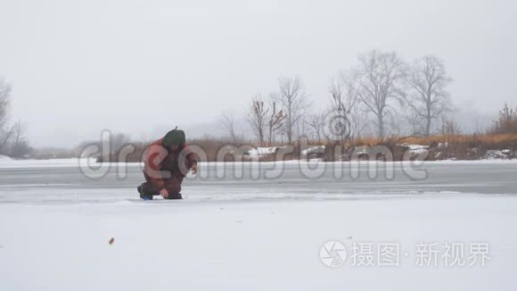 渔夫坐在结冰的河面上捕鱼视频