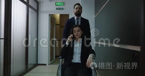 轮椅经理在办公室走廊打电话视频