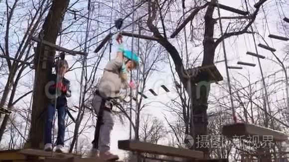 小女孩害怕爬上绳子公园。