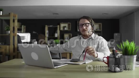 戴耳机的年轻经理在办公室工作视频