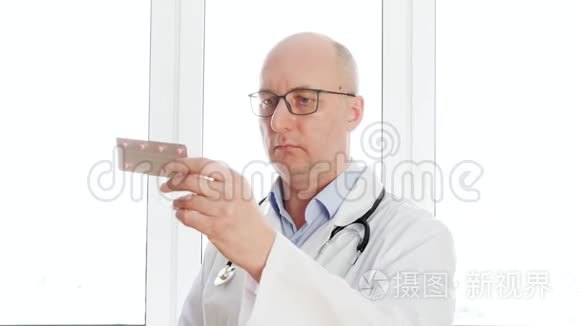 医生拿着平板水泡前摄像头关闭。 男药剂师在药房办公室把药丸照相机。