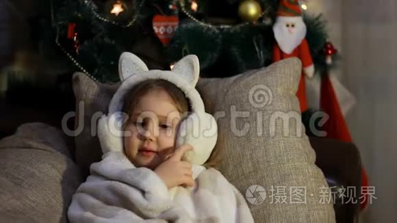快乐可爱的孩子在冬天的耳机里微笑，许下一个愿望，等待圣诞老人的礼物。 圣诞快乐