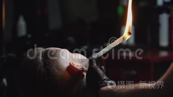 一个英俊的男人，耳朵里插着燃烧的纸棒