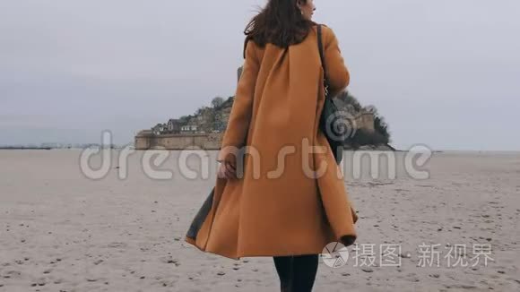 中型后景拍摄，优雅快乐的博客女性走在海底沙滩在史诗圣米歇尔城堡慢动作