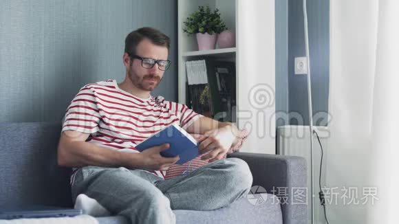 白人年轻英俊的男人在读一本书视频