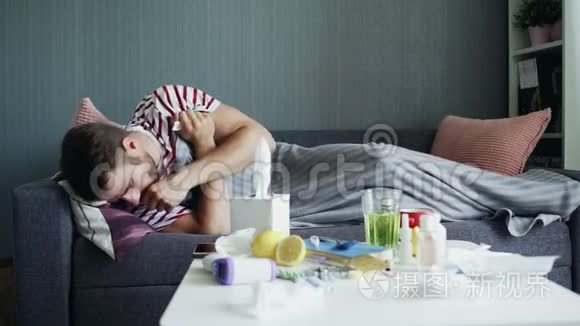 一个生病的年轻人试图在生病时睡着，躺在公寓的沙发上，躺在温暖的毯子下。