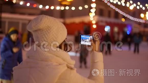 在智能手机上拍摄欧洲圣诞市场场景的快乐女人