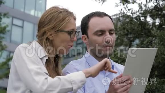 商务人士在外面用电子平板电脑开会。