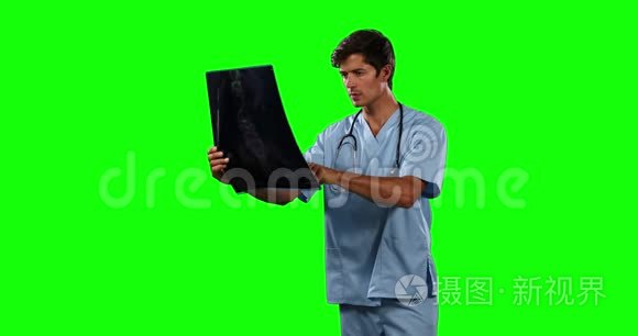 医生用绿色屏幕观看X光的正面视图