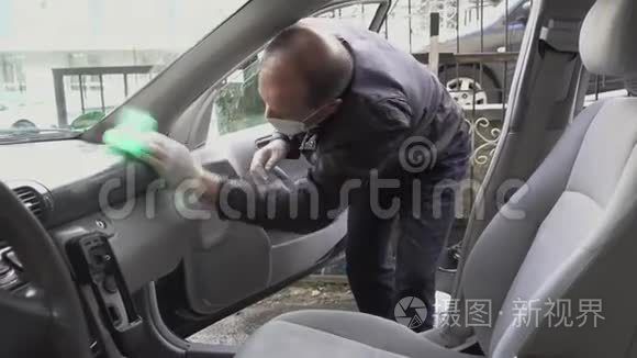 中年人用口罩和手套消毒汽车，打扫车门