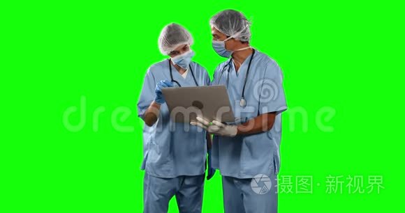 在带绿色屏幕的笔记本电脑上观看一些结果的医生的正面视图