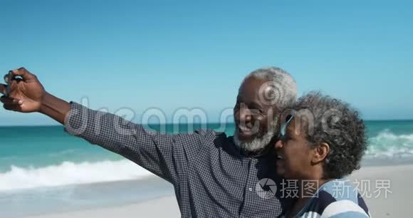 侧景老夫妇在海滩拍照