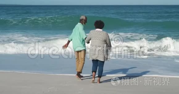 后景老夫妇穿过海滩