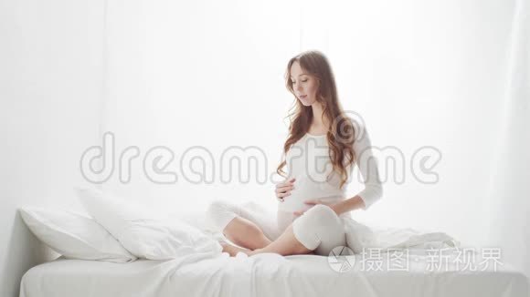 幸福的孕妇抚摸着她美丽的腹部。 怀孕母性和期望概念