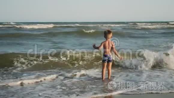 小男孩在海浪中跳进海里