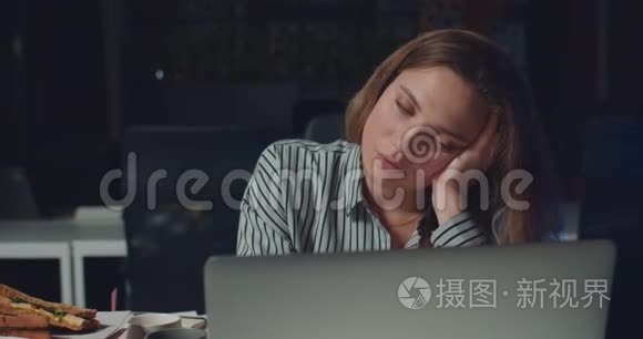 在笔记本电脑上长时间工作时，女人几乎睡着了。 累得昏昏欲睡的女上班族
