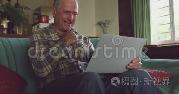 老人在家里用笔记本电脑微笑