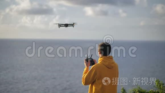 人类旅行者使用无人机拍摄照片或视频。 男性在旅行时学习驾驶无人机四翼飞机飞行和拍摄视频