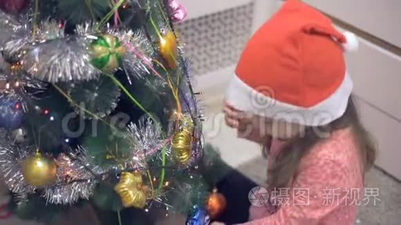 圣诞树附近的小女孩在考虑圣诞玩具。