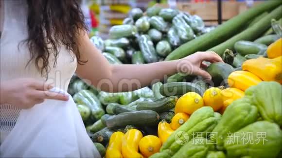 漂亮的年轻女人或妈妈正在超市里买东西，在超市里选择做饭的产品